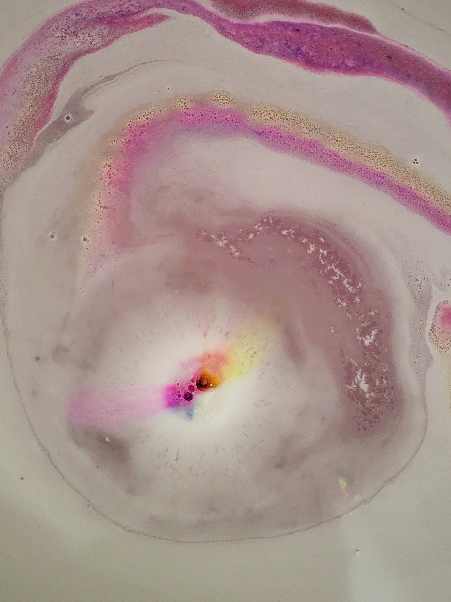 bath bomb in water foam and colourful swirls