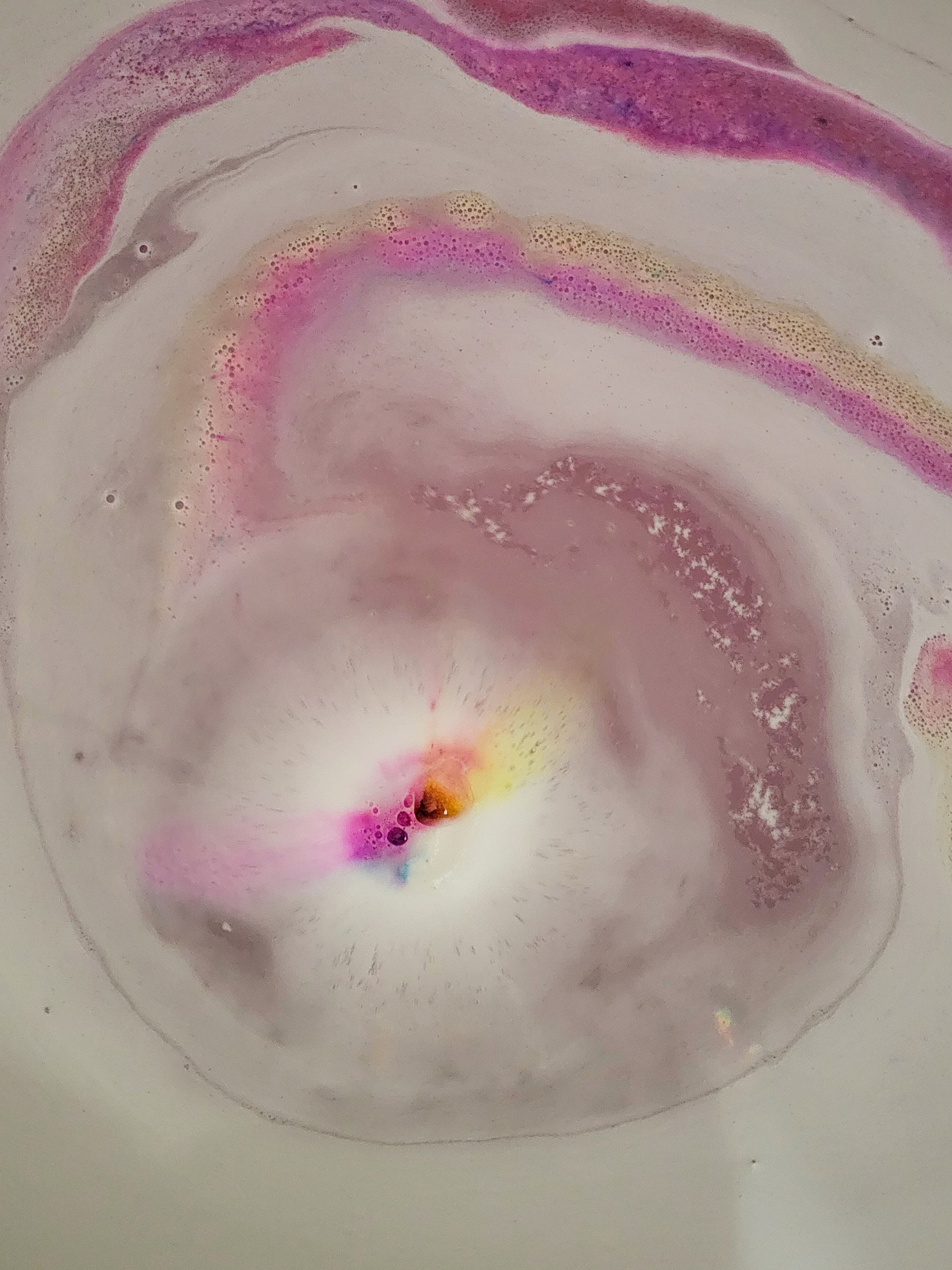 bath bomb in water foam and colourful swirls