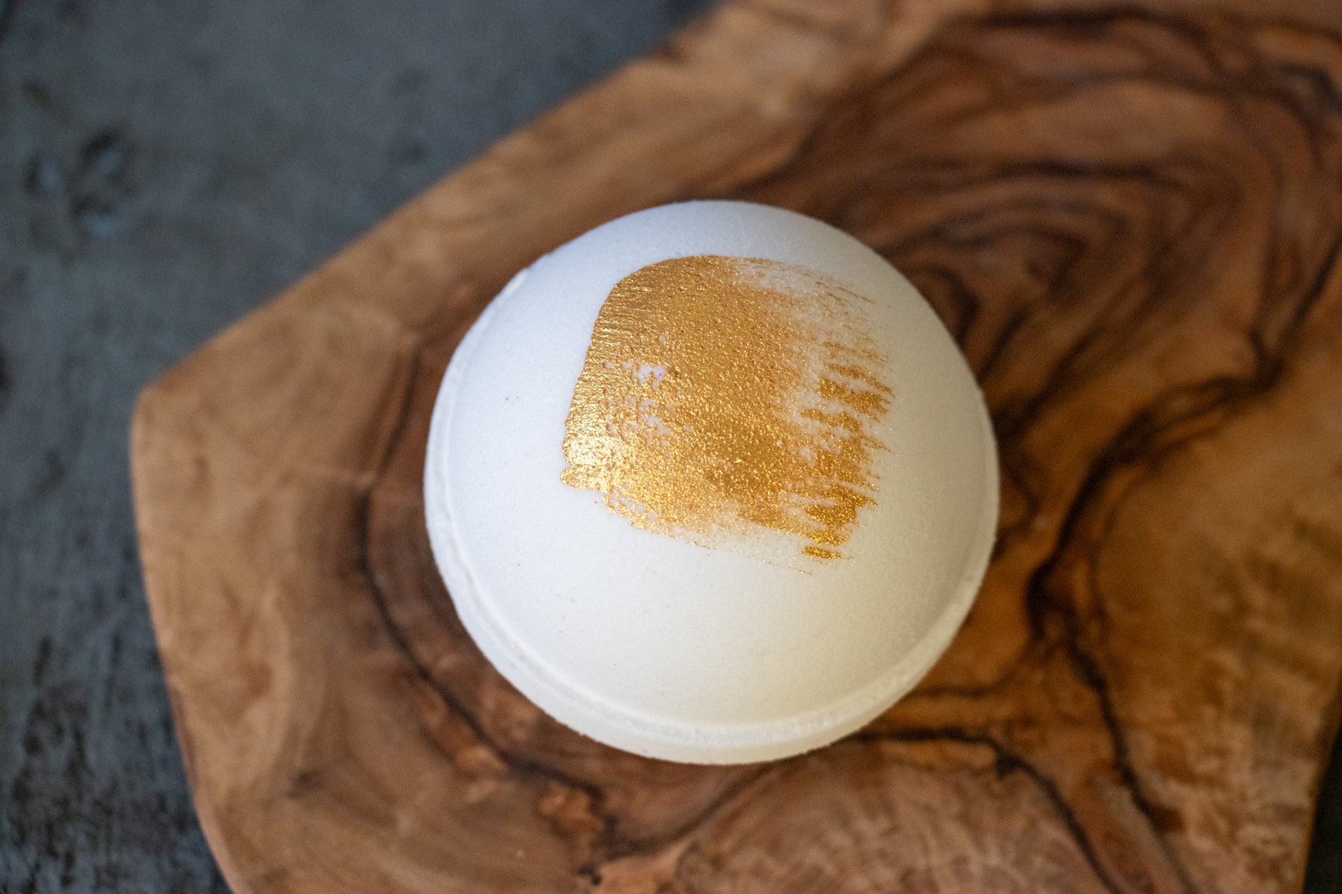 white bath bomb with gold brush stroke